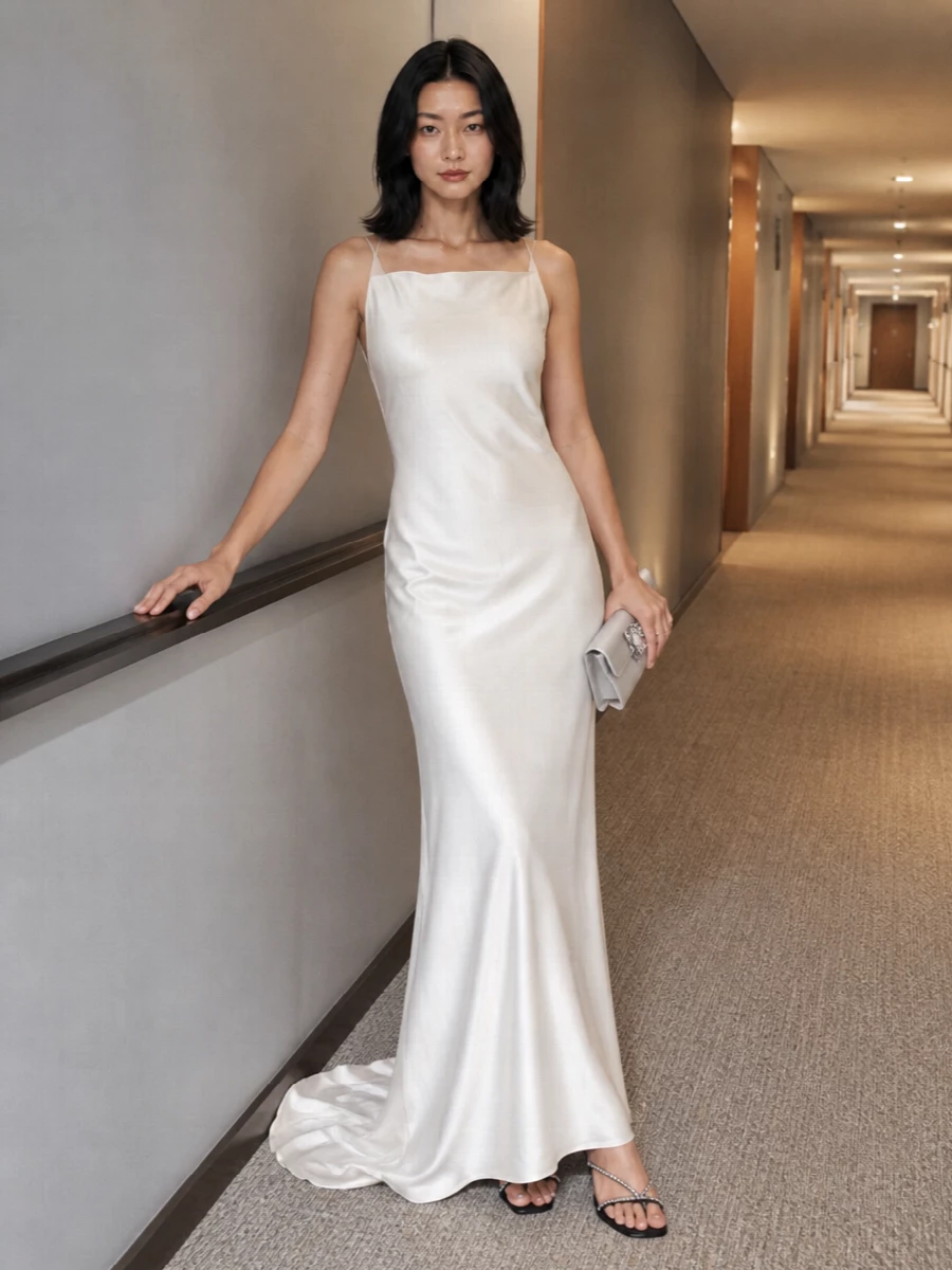 I chose the gown route rather than separates because the Margiela satin column gives a purer, more statuesque canvas for the jeweled champagne clutch, keeping the mood firmly in quiet, formal glamour. The ivory dress and bag read as a single, luminous story, while the low black crystal-trimmed sandal adds just enough contrast and sparkle without disturbing the clean lines. The result is a modern evening ensemble that works equally for winter galas, black-tie dinners, or contemporary bridal moments where subtlety matters more than volume.