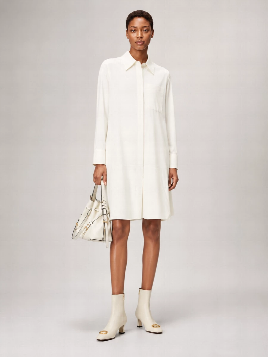 An ivory Jil Sander shirt dress and the Givenchy bucket bag create a quiet, architectural column in soft off white. The cream Valentino boots continue the monochrome line and tie into the bag’s gold detailing, giving a minimalist city outfit that feels calm yet considered for cooler seasons. Choosing the dress path keeps the silhouette pure and uninterrupted, which best suits the bag’s structured, quietly luxurious character.
