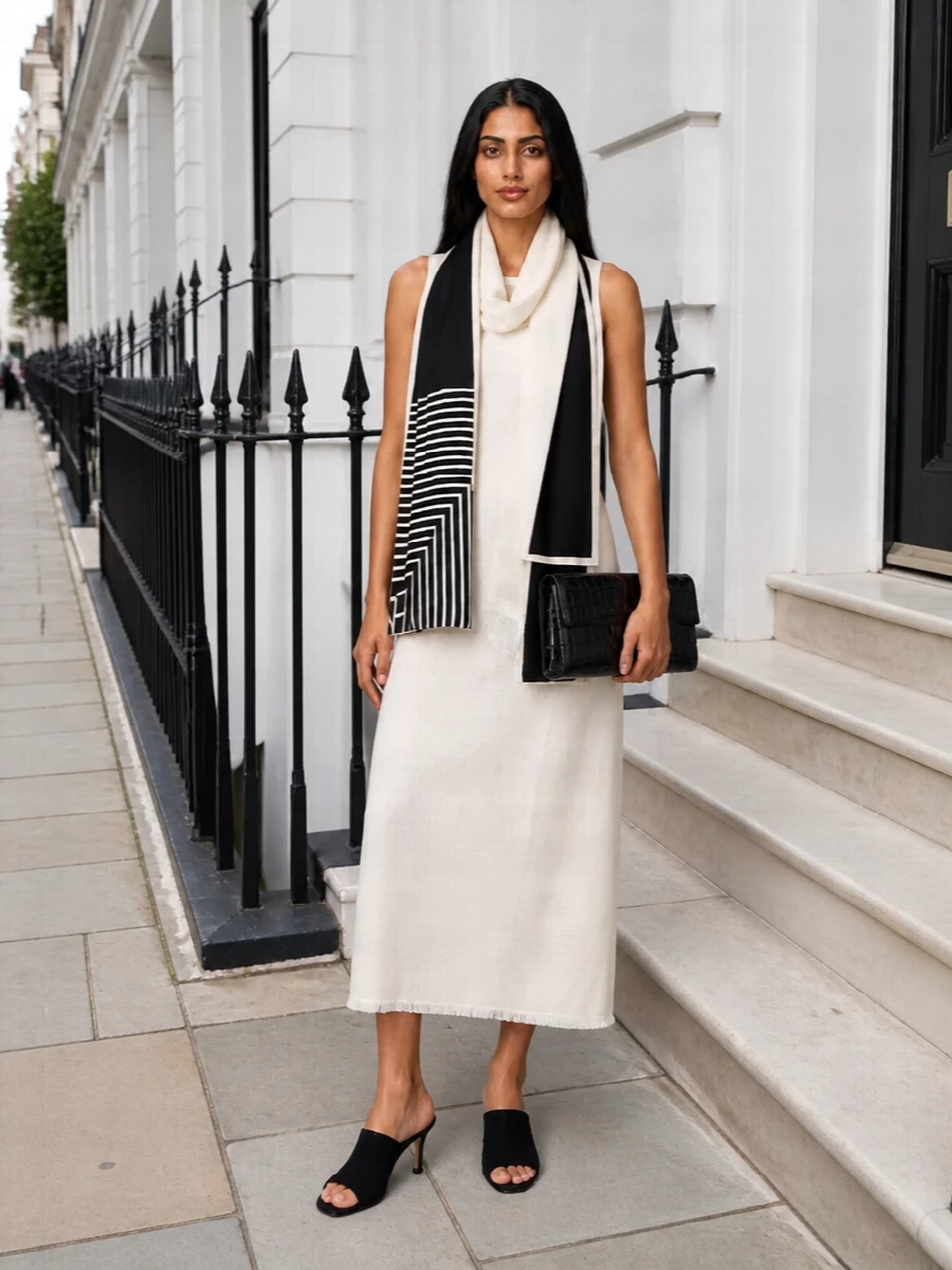 An ivory Totême shift becomes quietly dramatic when paired with sharp black suede mules and a structured croc-embossed clutch. The contrast of soft monochrome fabric and precise black accessories keeps the mood serene yet city-ready, ideal for dinners or late gallery openings.