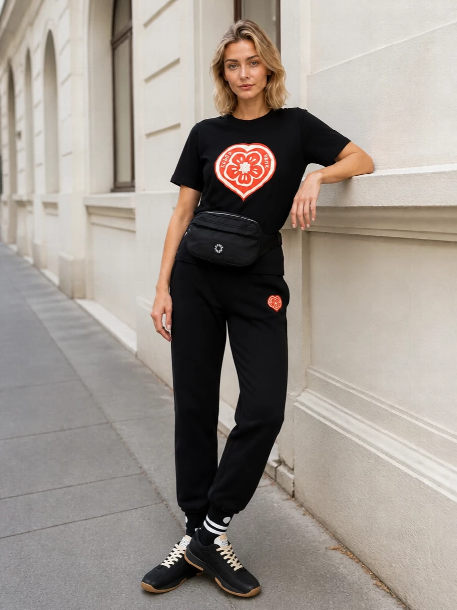 This is a tight, monochrome Kenzo-driven city uniform built around graphic hearts and clean sport lines. The relaxed tee, straight track pants and quilted sneakers sit in the same brand universe, so the proportions feel cohesive rather than casual. A compact belt bag and graphic socks finish it with just enough detail for off-duty days that still read sharp.