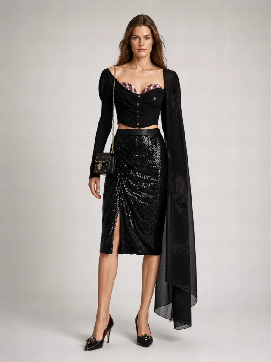 A sharply sculpted Vivienne Westwood top meets an equally decadent sequinned pencil skirt, creating a long, lean line that frames the décolletage and cinches the waist. Patent-shine stilettos and a studded black cross-body sharpen the romance, keeping the mood unapologetically after-dark and couture-leaning. Every element is graphic and controlled, so the drama reads precise rather than fussy.