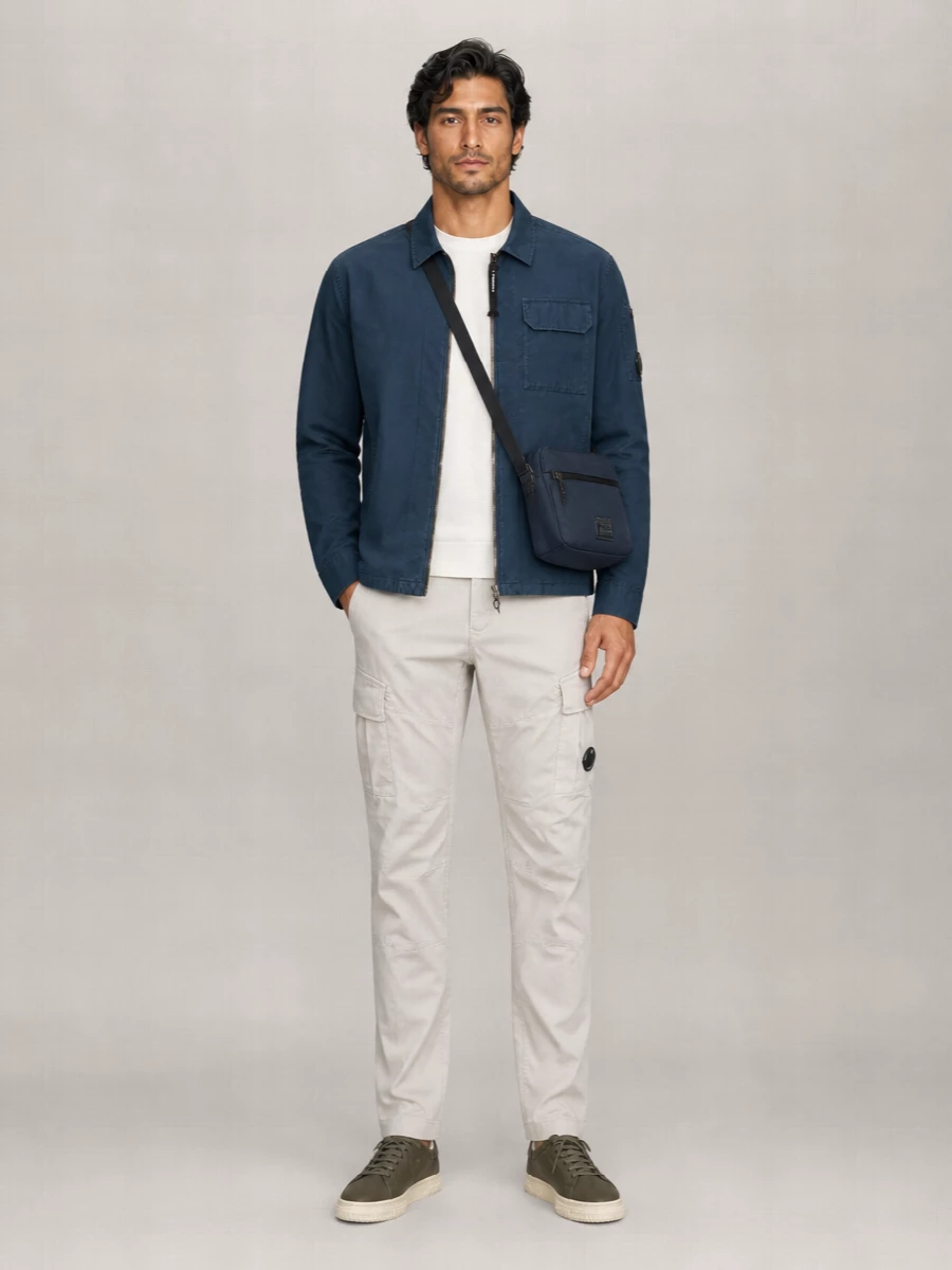 Ink navy up top, soft off white at the core, and light stone cargos keep this C.P. Company outfit sharp but relaxed for city days. The straight leg grounds the regular jacket block, while olive leather sneakers and a compact Porter crossbody introduce muted depth without breaking the neutral rhythm.
