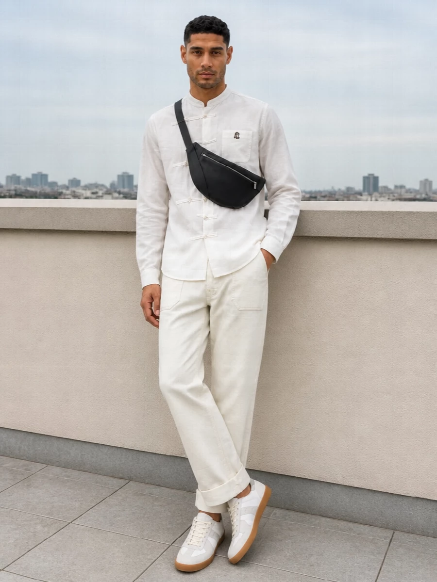 The mandarin-collar shirt and off-white straight-leg trouser form a calm, tonal base that feels sharp without tipping into formality. Margiela’s gum-sole sneakers keep everything light on the eye, adding just enough structure underfoot. A black curved sling crossbody finishes the outfit with a precise, technical note that grounds the softness without breaking the minimalist mood.