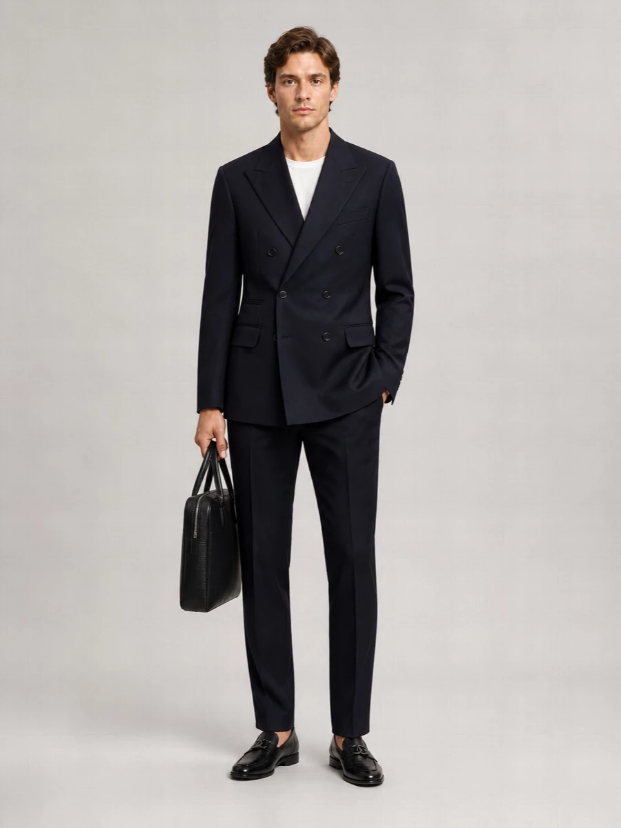 This is a quietly assertive navy-on-navy dinner ensemble that nods to the Prada blazer’s precision without feeling like a full tuxedo. Brunello Cucinelli and Jil Sander tailoring keep the lines architectural, while black loafers and a slim Ferragamo briefcase add just enough formality for serious evenings and boardroom-adjacent occasions. The result is modern Italian restraint, all depth and structure with no noise.