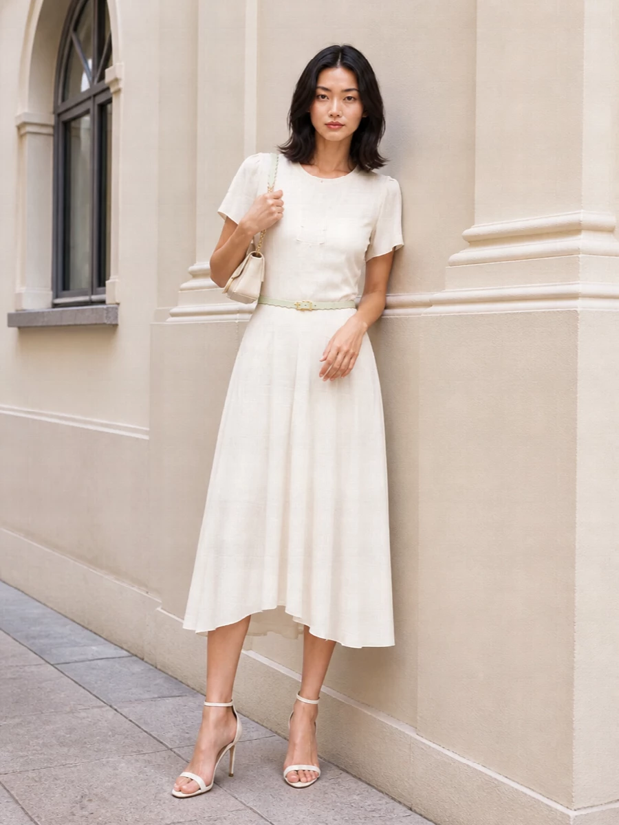 An all-ivory palette keeps the focus on the dress’s soft movement, with slender straps and a compact cream shoulder bag adding just enough formality for dinners or gallery evenings. The pastel scalloped belt gently defines the waist and brings a modern, feminine detail while staying light and refined.