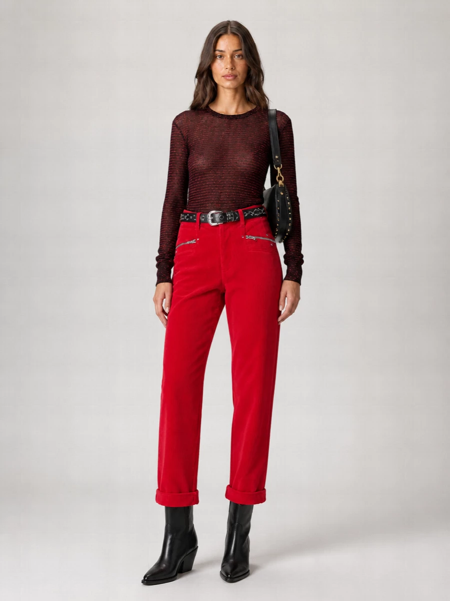Bright red corduroy meets a sheer black and red knit for a Parisian streetwear mood that feels confident rather than loud. The pointed black western boots and studded belt sharpen the cropped, high-rise silhouette, while the black suede hobo keeps the metal and texture story cohesive. It is an easy off-duty uniform with a quietly rebellious edge that works from daytime errands to late bar nights with only a change of lipstick.