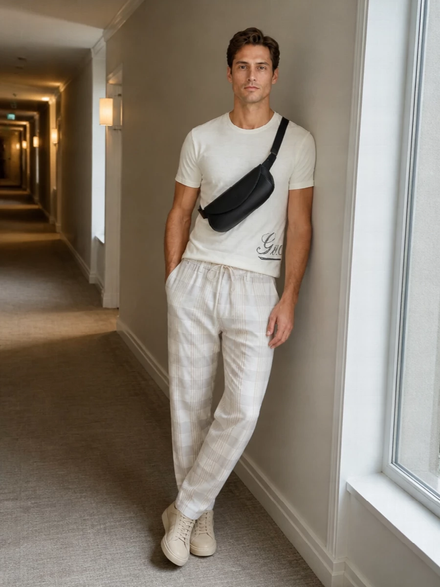 Gucci’s off-white tee sits against the softly checked Uma Wang trouser for a light, tonal take on casual polish. Sand suede Church’s sneakers keep the line relaxed yet refined, grounding the neutrals with quiet texture. Jil Sander’s precise black bag adds just enough graphic contrast to underline the minimalist, quietly luxurious mood.