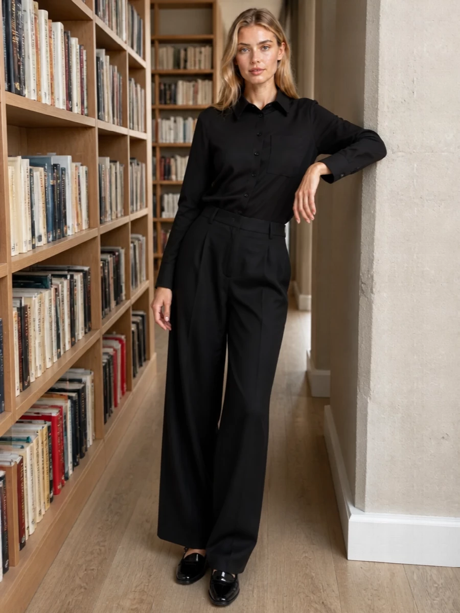 An all-black, sharply cut column of Jacquemus shirting and Mm6 wide-leg tailoring lets the glossy Margiela Tabi read as a considered, almost jewel-like detail. The asymmetric placket against a pure, high waist keeps the mood quietly subversive, poised between gallery-ready minimalism and late-dinner polish. Choosing the top and trouser path over a dress preserves that precise, androgynous balance the shoes naturally lean into.
