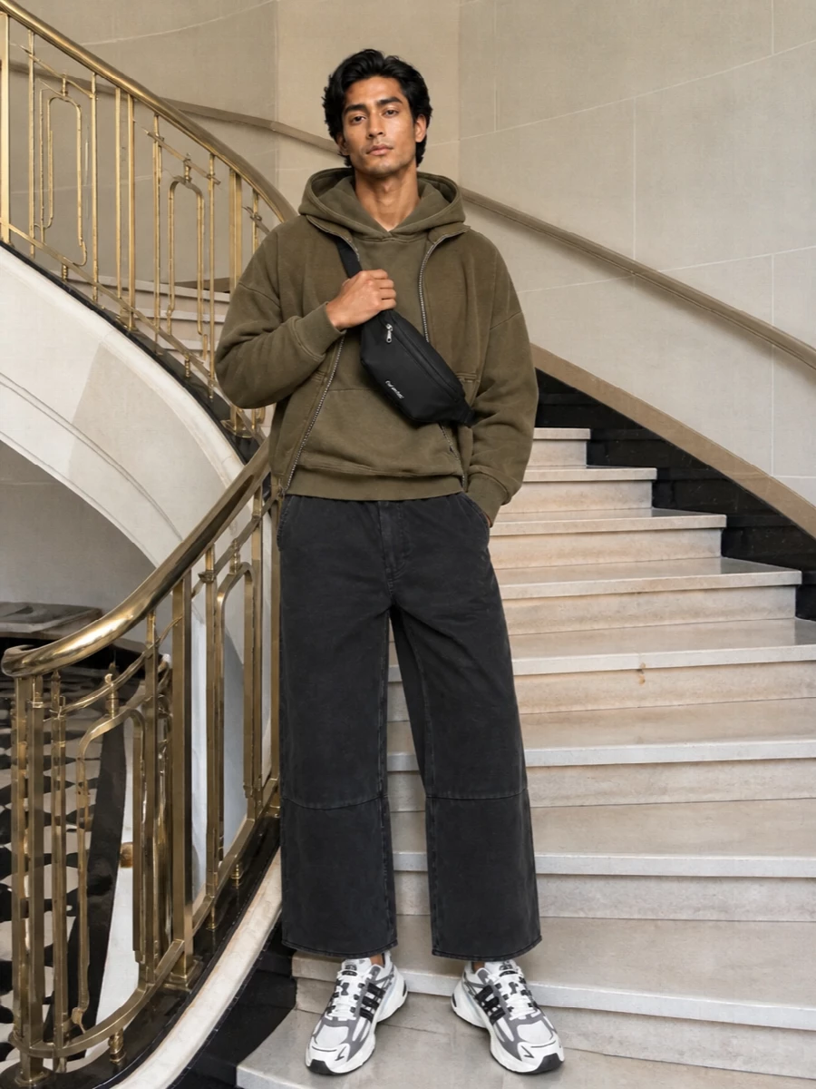 Olive and washed black keep this Entire Studios story tight, with layered hoodies on a cropped outer shell and soft architectural trousers. The technical runner and compact belt bag add movement without breaking the quiet, street-led volume. It is an easy off-duty uniform that still feels designed from every angle.