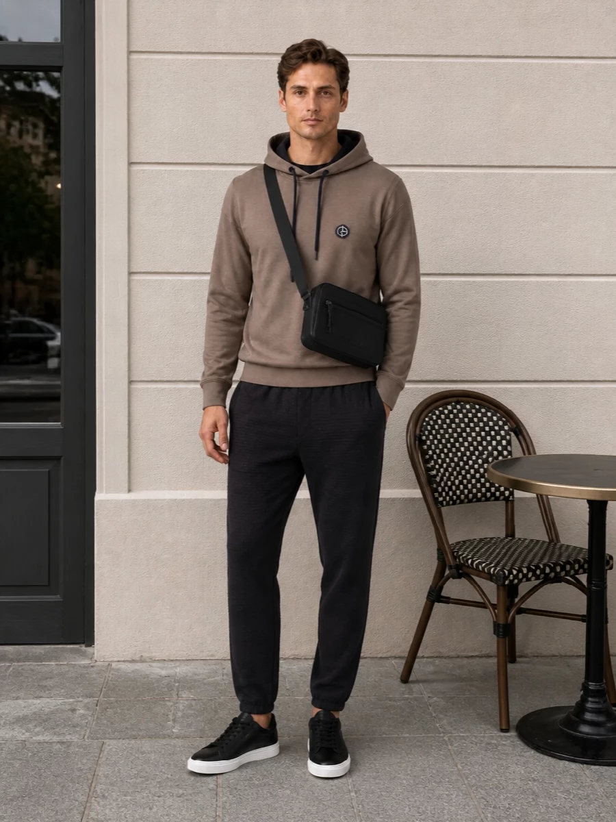 Taupe and inky navy sit against deep charcoal and black for a quietly graphic, hoodie-on-hoodie take on off duty. The straight jogger and sleek low tops keep the silhouette clean, so the textures and tiny logo hits do the talking. It is city casual that reads considered from coffee runs to late flights.