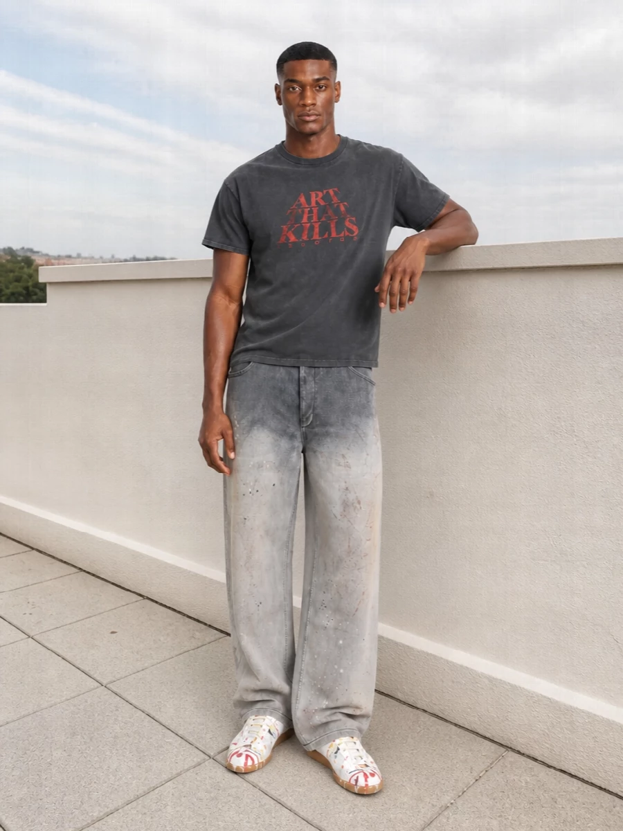 Washed graphic jersey meets art-treated wide-leg denim for a grungy, studio-kid uniform that still reads considered. Paint-splatter sneakers echo the tee’s attitude, while a big Givenchy tote and clean sport socks keep it grounded for actual city days. The result feels like you are walking from gallery opening to late-night gig without changing a thing.