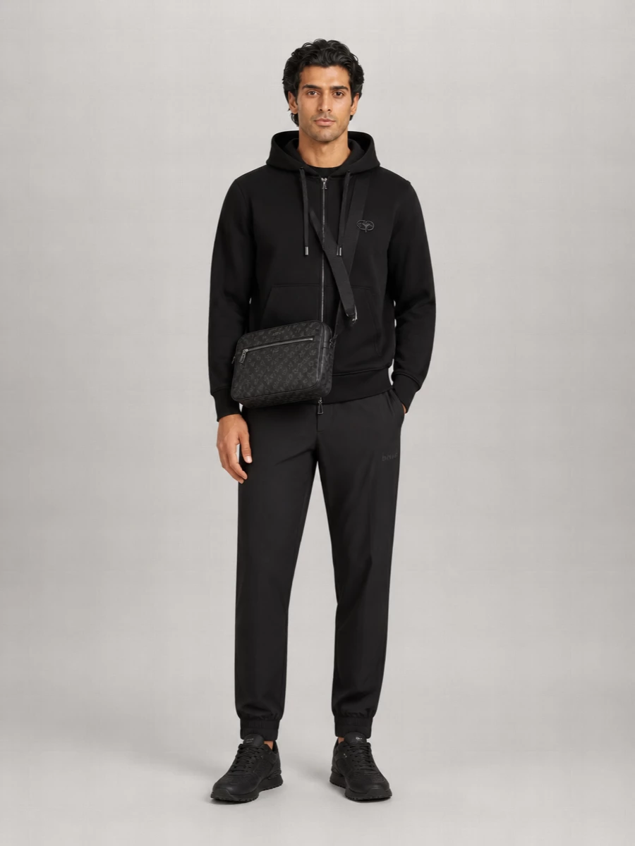 A monochrome, sport-driven city uniform built around layered black hoodies, technical track pants and stealth runners. The Gucci crossbody introduces a single hit of quiet luxury, keeping the whole thing polished without losing its athletic edge. It is made for travel days, late commutes and weekends where comfort needs to stay sharply put together.