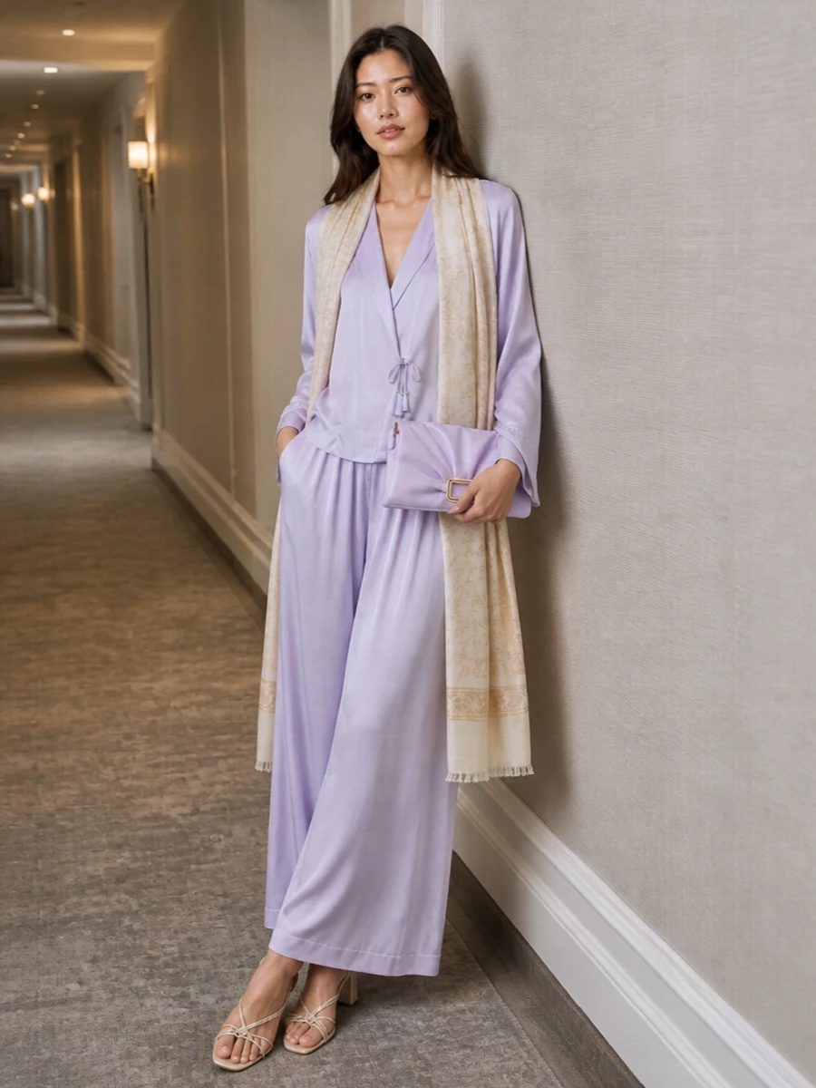 A head-to-toe lilac satin column keeps the mood soft, romantic and quietly polished, ideal for warm evenings where you want movement and light. Champagne sandals and a lilac clutch add a subtle glow, while the ivory stole gives a whisper of texture and coverage without disturbing the pastel haze.