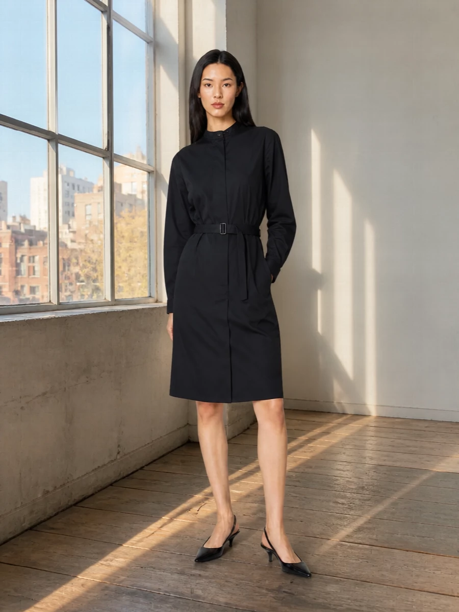 The inky Lemaire shirt dress, cinched cleanly at the waist, channels the same intelligent, understated structure as the Mulberry satchel for a unified, quietly assertive silhouette. Gucci’s sharp kitten-heel slingbacks keep the line sleek and formal without tipping into overt glamour, letting the black and gold hardware narrative stay coherent. Choosing the dress route rather than separates keeps the focus on proportion and polish, ideal for boardroom days that segue into restrained evening plans.