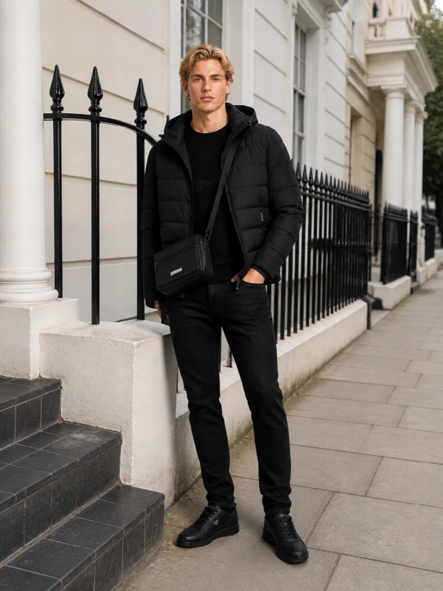 A monochrome city uniform that keeps the focus on clean lines and subtle texture shifts. The padded jacket, lean denim and sleek runners create a modern, sport-influenced silhouette that moves easily from commute to weekend. The compact crossbody finishes it with practical polish, without breaking the all-black rhythm.