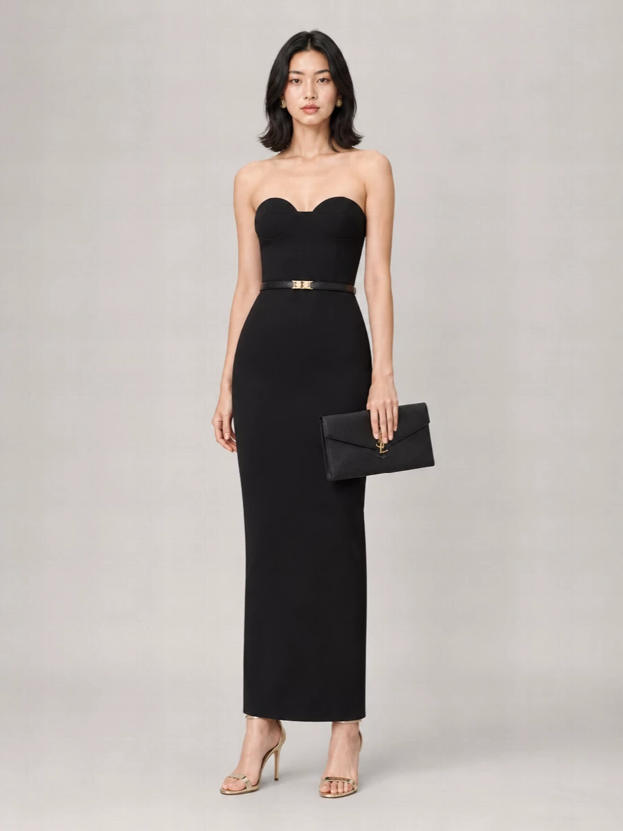 A statuesque black column gown is sharpened with whisper-thin champagne stilettos and a structured Saint Laurent envelope in matching black and gold. Versace studs and a slim waist belt quietly link the metal tones, keeping the focus on clean lines and a long, uninterrupted silhouette. The result is restrained, modern evening dressing that feels confident without any embellishment.
