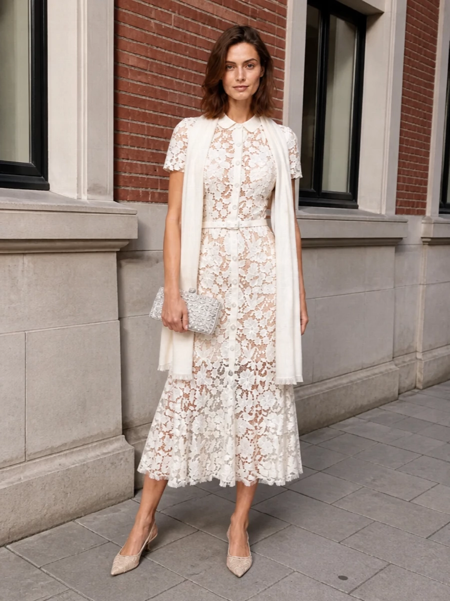 An all-ivory, lace-on-lace story keeps the Self-Portrait dress centre stage, with nude lace slingbacks and a crystal-dusted minaudière quietly amplifying the romance. The result is soft, light and impeccably polished for summer weddings or garden parties where you want understated glamour. The sheer ivory stole adds a practical, whisper-fine layer that never distracts from the dress’s intricate pattern and defined waist.