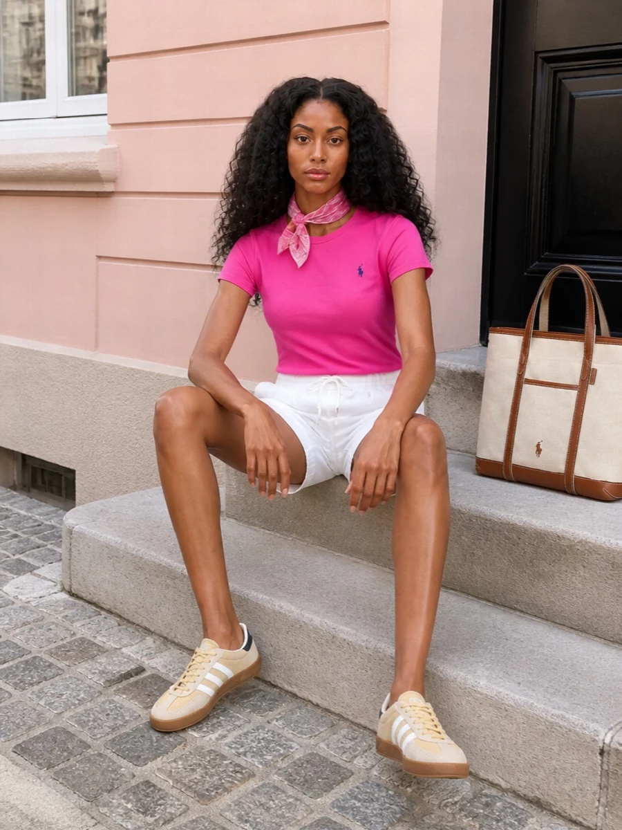 Bright, optimistic pink meets crisp white and sand for a clean take on off-duty prep. The tee and shorts keep the lines simple and airy, while neutral sneakers and a structured canvas tote bring just enough polish for city walks, coffee runs, or a relaxed seaside afternoon. A soft pink neckerchief adds a discreet hit of personality without disturbing the easy balance.