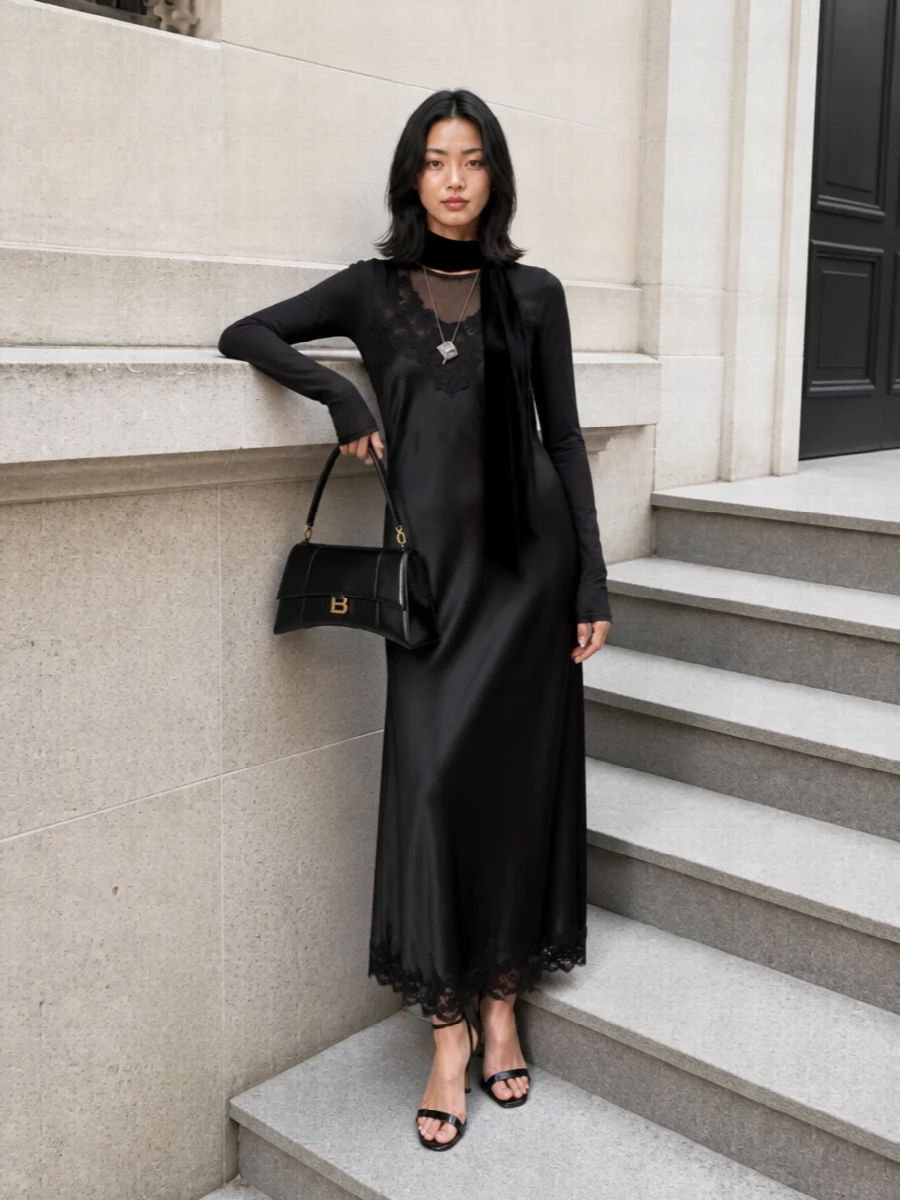 A liquid black column, quiet at first glance, becomes more intriguing the closer you get. Patent slingbacks, a sculpted top handle and a single silver pendant keep the mood precise, not fussy. The velvet scarf adds just enough texture to turn this into a modern after-dark uniform rather than a simple slip dress moment.