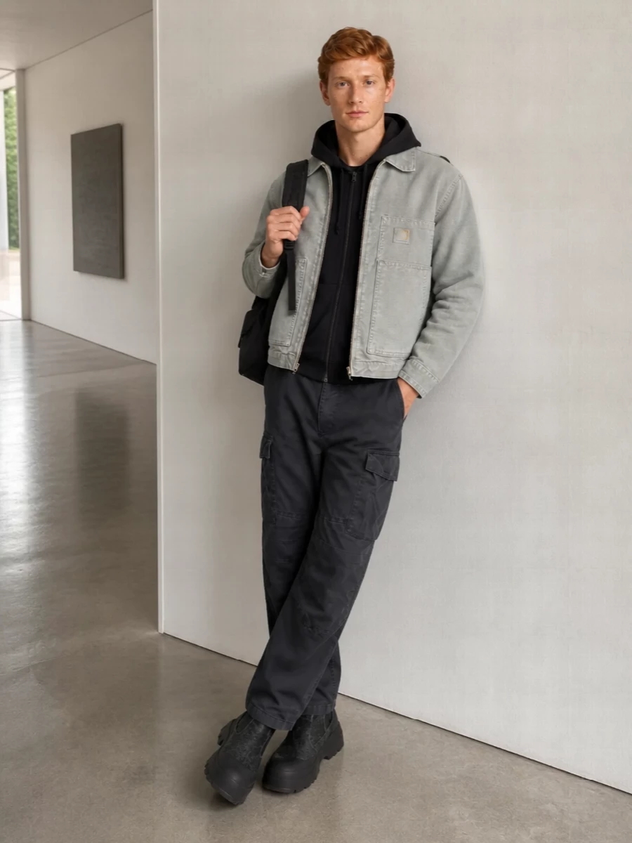 Carhartt workwear meets refined street with a dark, monochrome base that lets the washed grey jacket stay the focus. Relaxed cargos and chunky Diesel boots give the cropped top block real weight, while Y-3 accessories pull everything into a sharper, more directional lane. The result is cold-weather city kit that feels utilitarian but still quietly design-conscious.