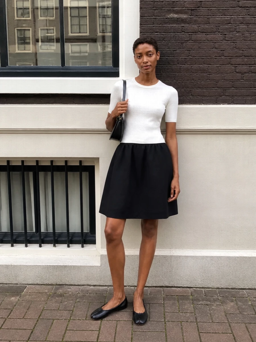 This pairing leans into a monochrome, gallery-dinner mood, with the Totême two‑tone dress echoing the Margiela tabi’s black and ivory dialogue. The clean knit bodice and soft A‑line skirt keep the line calm and elongated, letting the split toe read as a considered detail rather than a statement. I chose the dress route over separates to maintain a single, uninterrupted column that feels quietly formal yet relaxed enough for long city evenings.