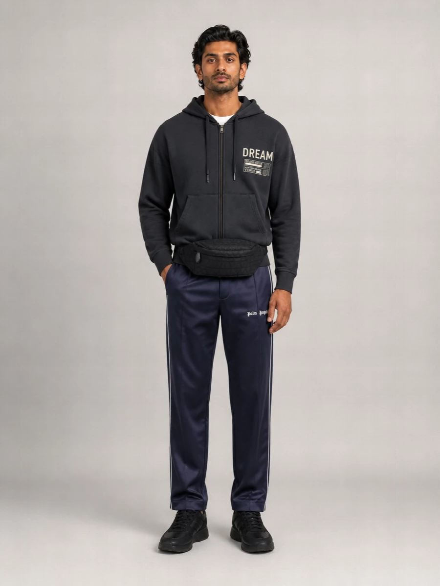 Charcoal, navy and black keep this set tight and graphic, so the hoodie’s print can do the talking. The Palm Angels track pant and Valentino runners lock in a clean sport profile, while the belt bag adds low-key logo attitude without cluttering the lines. Built for city days where comfort still needs a point of view.