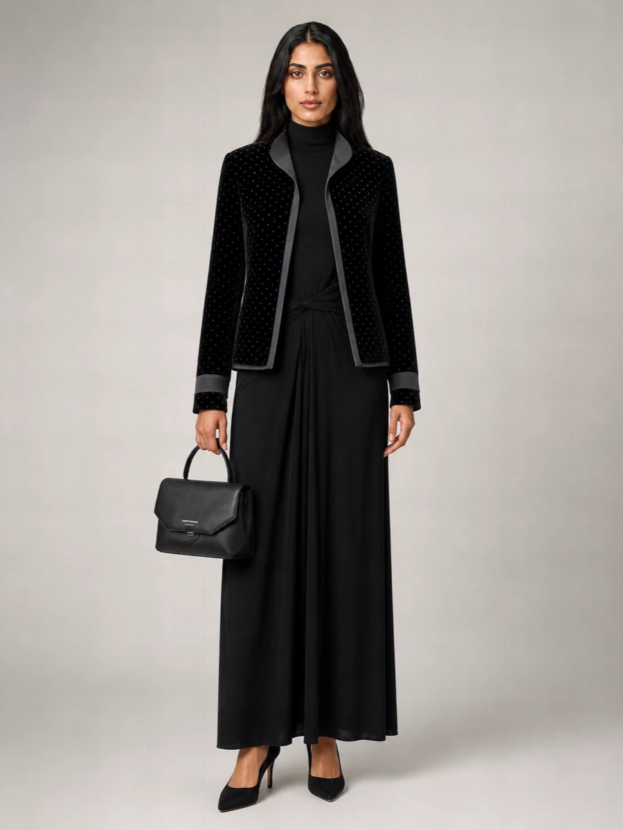 I am styling the velvet polka dot Emporio Armani jacket with a dress rather than tailoring, so the outerwear reads like a refined evening topper over a single, uninterrupted column. The Fabiana Filippi turtleneck maxi gives that inky, fluid base that lets the texture and subtle dots play in the light, while the black Gianvito Rossi pumps and structured Emporio Armani bag keep the mood composed and quietly formal. It is a modern cocktail-to-dinner ensemble that feels rich in texture but restrained in detail.