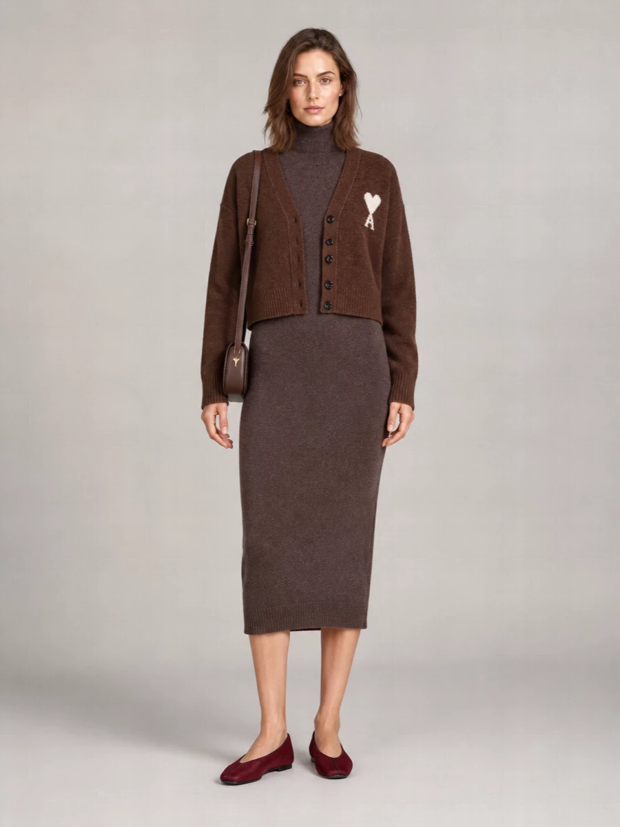I am styling the cardigan as outerwear over a dress rather than with separates, because its cropped, relaxed shape is perfect over a long knit column and keeps the outfit from feeling busy. The chocolate Ami heart cardigan over the slim Mm6 turtleneck dress creates a deep brown tonal story with subtle texture contrast, while the burgundy ballerinas and chocolate shoulder bag add quiet richness without introducing new colours. The result is a softly sculpted, city-ready knit ensemble that reads warm, composed, and quietly confident for autumn and winter days into dinner.