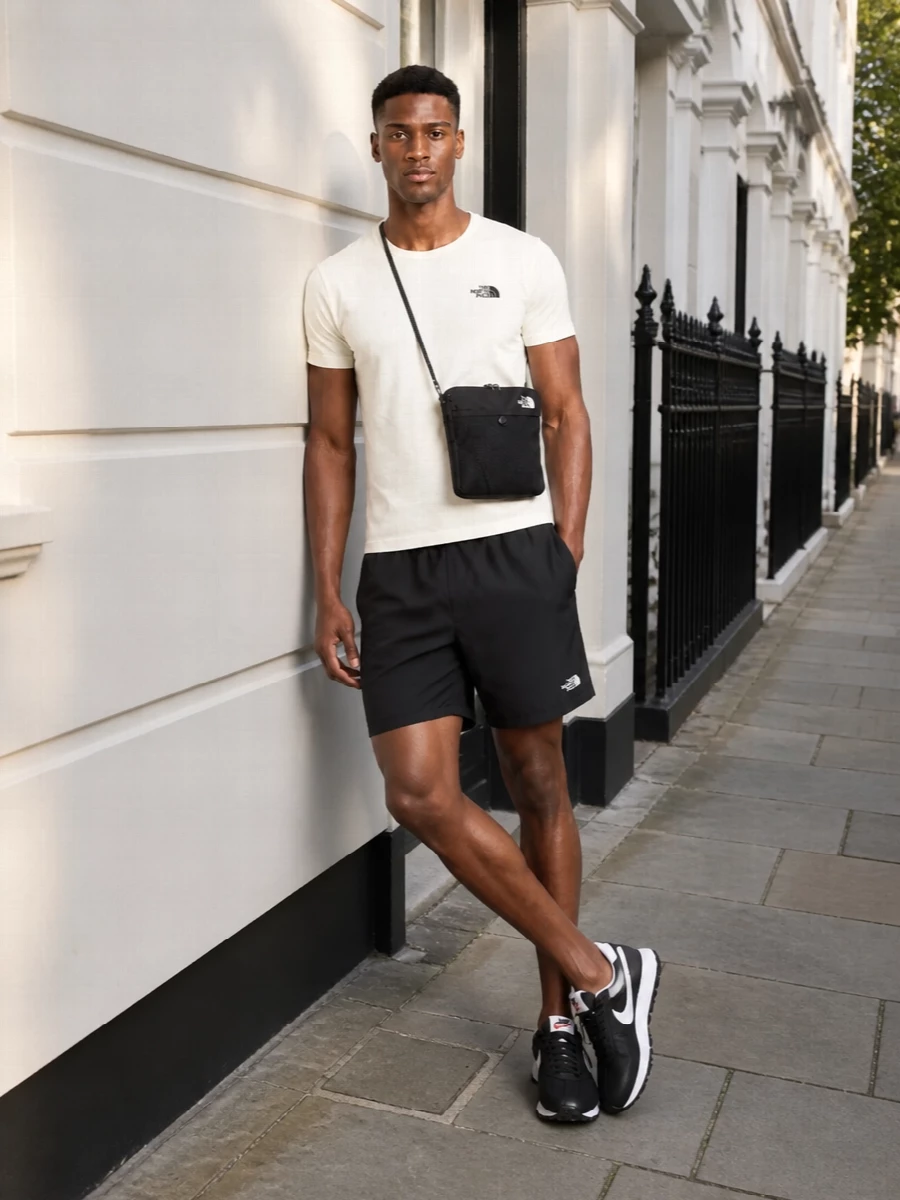 Off white on top and sharp black below creates a clean, graphic North Face base that feels ready for city miles or light trail time. The mid-thigh shorts keep the proportions agile, while the retro runners add just enough street energy without fighting the minimal palette.