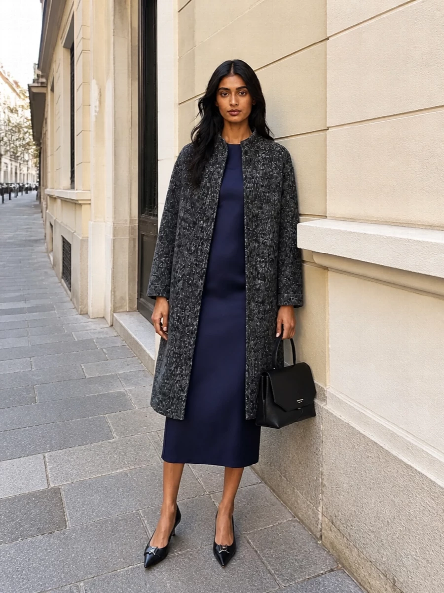I am building around the dress route here, because the ink navy column underlines the coat’s sculpted texture and keeps the whole composition clean and refined for city evenings. The pointed pumps and structured black bag sharpen the silhouette, so the charcoal coat can read as quietly dramatic rather than bulky. It is a gallery-to-dinner combination that feels composed, tonal and deliberately pared back in both palette and branding.