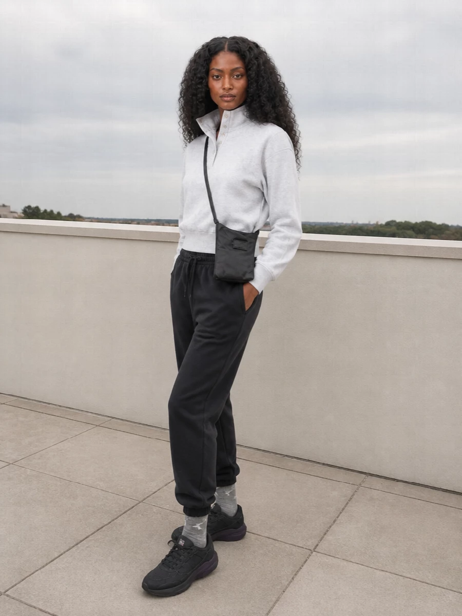Washed black fleece and a cropped heather pullover keep this set grounded in easy streetwear, all about soft structure and low-key contrast. Dark technical runners and a slim cross-body keep the lines clean and functional, while tonal logo socks add a quiet styled touch. It is an off-duty combination that moves easily from travel days to long city walks without feeling overthought.