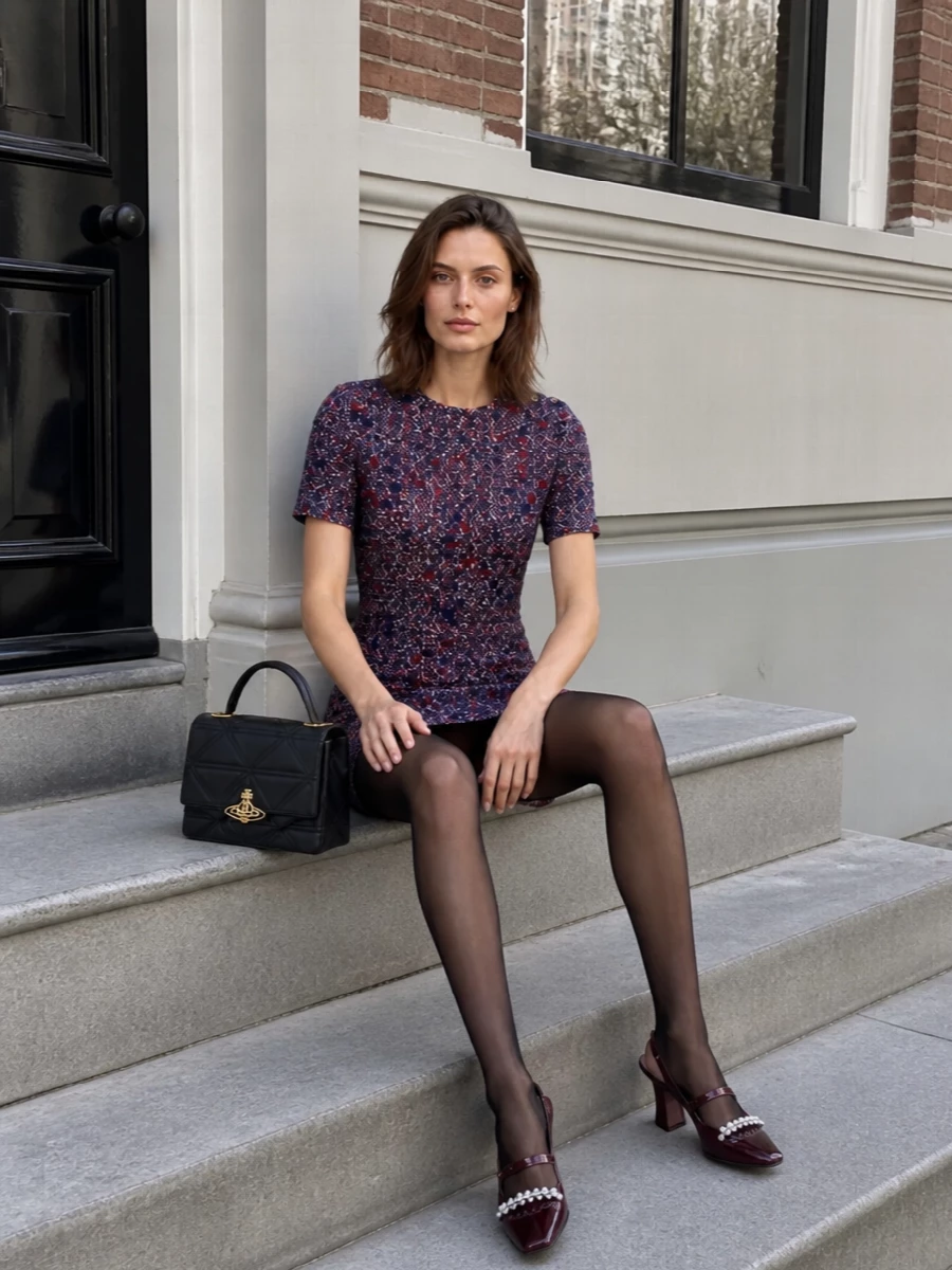 Gucci’s tweed mini shift stays firmly in that polished, Sixties-inspired preppy space with burgundy block-heel slingbacks that pick up its warm crimson flecks. A quilted black top-handle bag sharpens the mood, giving the outfit a city-ready finish that still feels quietly luxurious. Add sheer black tights and simple pearl studs to keep the proportions chic and winter appropriate.