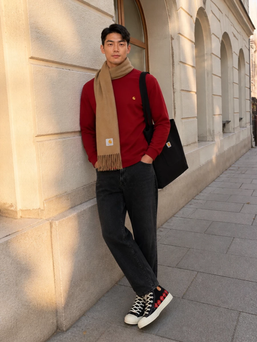 Brick red and washed black keep this rooted in clean streetwear, with the straight-leg denim giving the tee an easy, grounded base. Graphic high-tops echo the red hit without overdoing it, and the workwear tote plus camel scarf add just enough function and warmth to feel ready for long city days. It is a simple, durable uniform that still reads considered from head to toe.