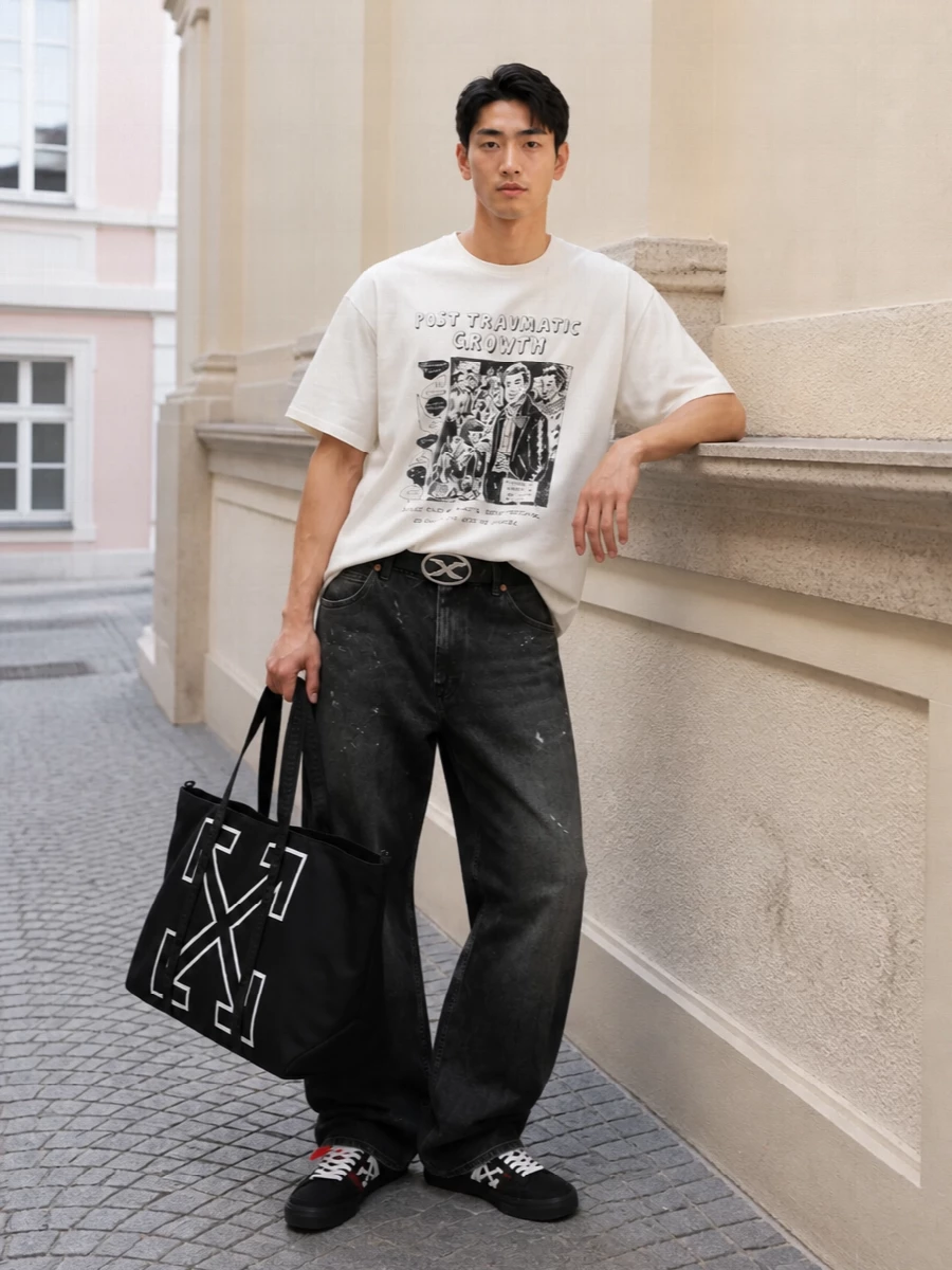 A sun-bleached graphic tee drops into loose, grungy wide-leg denim for a slouchy, early‑2000s street feel. Graphic Off-White skate sneakers and a bold arrow tote keep everything in a sharp black and washed‑neutral story. The Diesel logo belt is the only shiny hit, nodding to Y2K without drowning the worn-in mood.