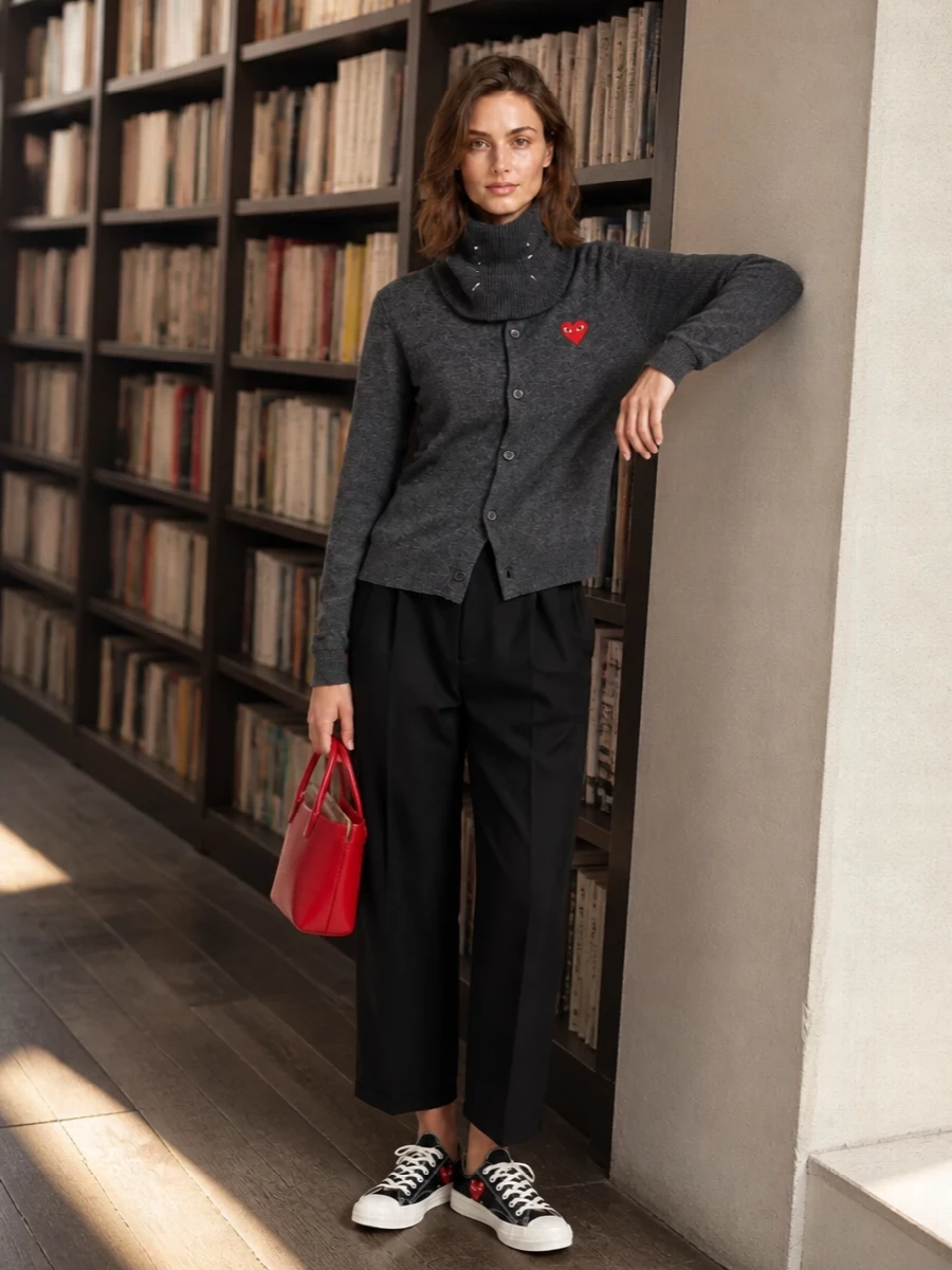 Charcoal, black and deep grey keep this CdG Play cardigan firmly in a clean, urban register, with cropped tailored trousers giving it an easy, modern line. Graphic Play sneakers and the sharp red mini tote echo the heart logo so the color feels intentional rather than random. A charcoal scarf tops it off with soft structure and a discreet, insider detail that still sits comfortably in the minimalist story.