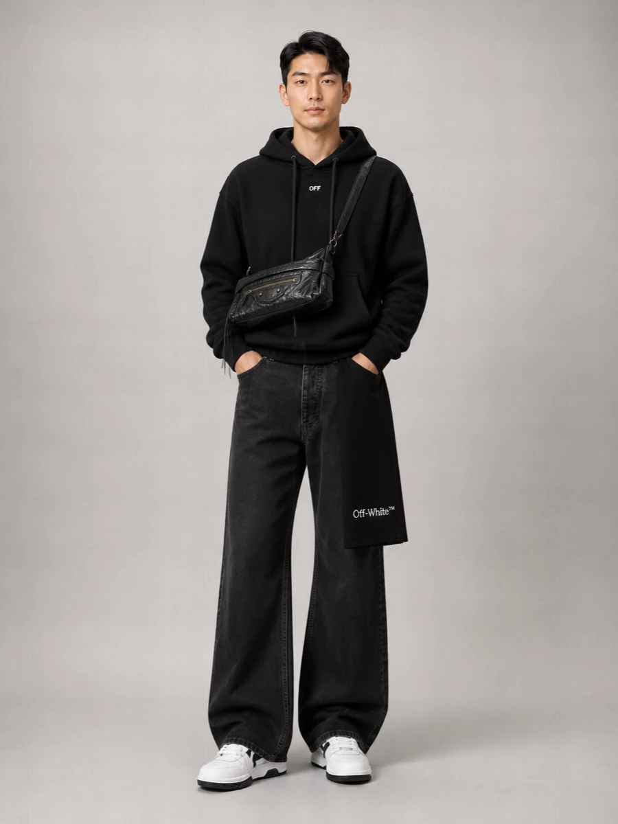 A stripped-back Off-White hoodie sits over washed black wide-leg denim for a quiet, graphic take on streetwear that leans more considered than casual. Black and white court sneakers keep the palette tight and clean, while the Balenciaga crossbody and ribbed scarf add just enough detail and texture to feel intentional without disturbing the minimal mood.