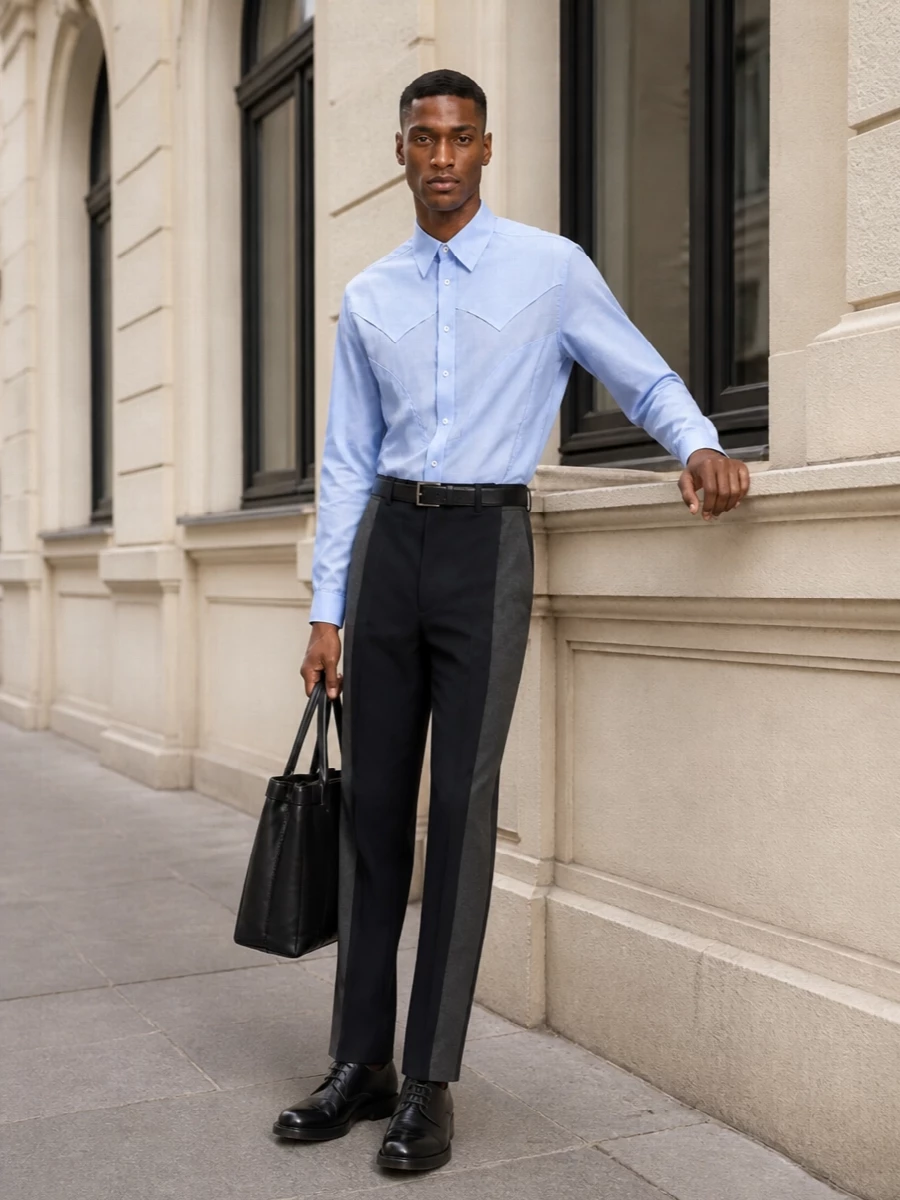 A pale sky-blue Margiela shirt meets crisp, high-waisted two-tone tailoring for a clean, architectural take on smart dressing. Polished black derbies and a structured black leather tote keep the palette disciplined and refined, letting subtle panel lines do the talking. The result is quietly assertive, ideal for days that move from studio to dinner without a change of clothes.
