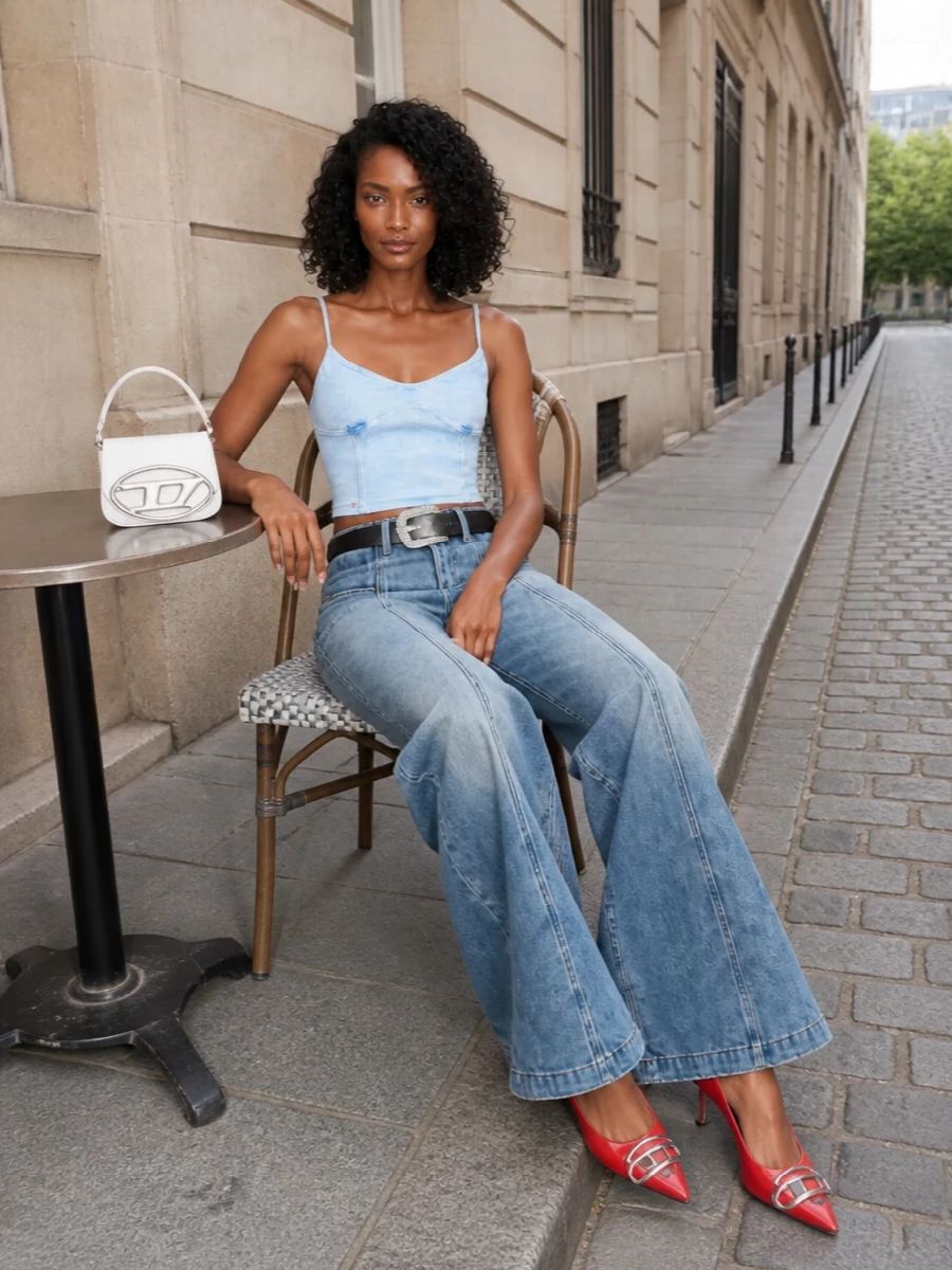 This is pure Diesel nightlife energy built around that dramatic high-waist wide-leg maxi. The washed sky-blue cami keeps the torso sleek and minimal so the volume starts at the hip, while the crystal-logo belt and transparent red slingbacks pull the eye up and down in one clean vertical line. A sharp white mini bag finishes it with a tight pop of brightness, all red hits syncing to the back patch for a tight, graphic Y2K story.