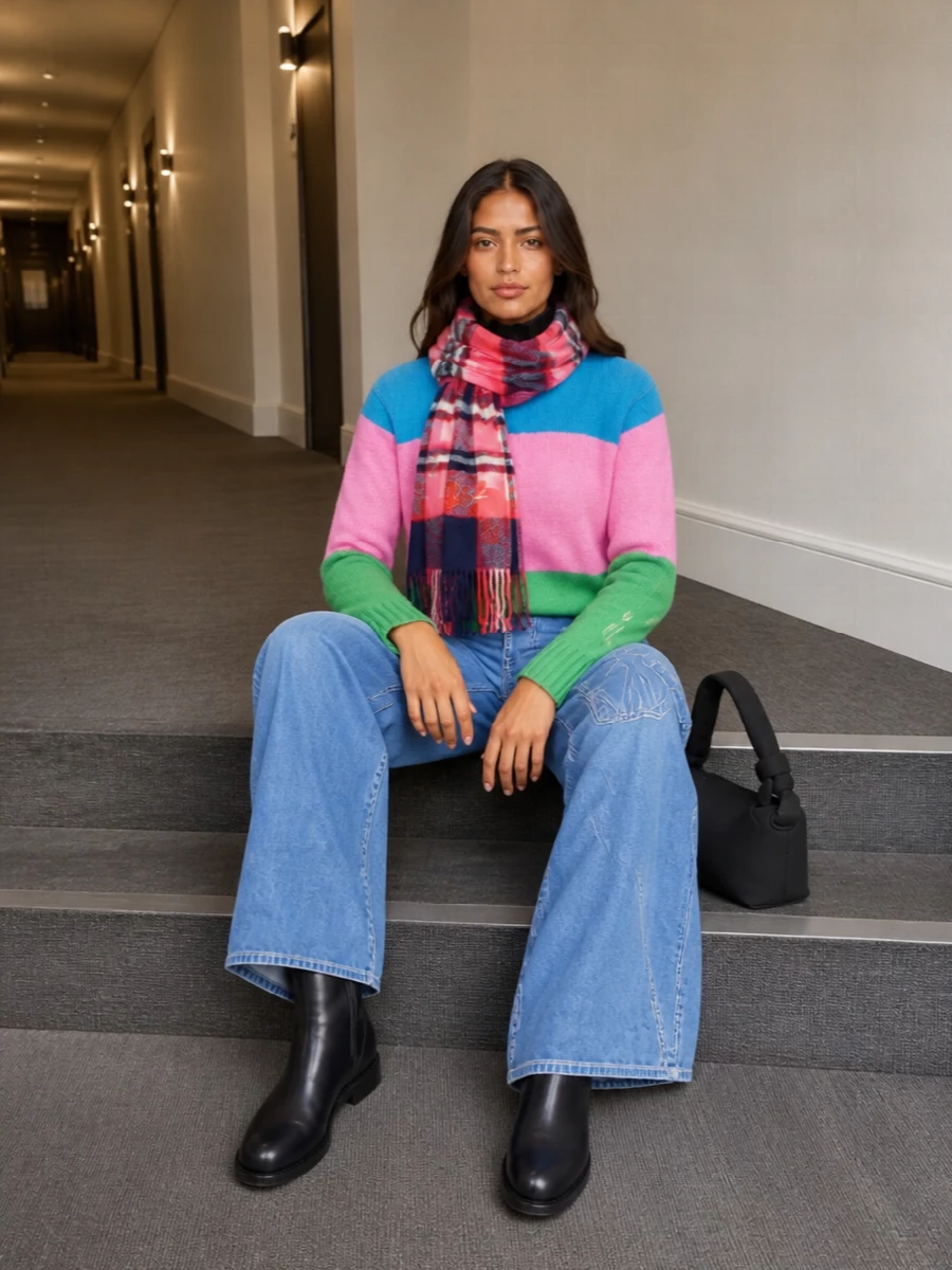 Graphic but easy, this pairing lets the striped knit lead while the wide-leg light-wash denim relaxes the energy. Inky Chelsea boots and a soft black shoulder bag quietly anchor all the color. A hit of tartan at the neck pulls the pink and blue together and leans into that offbeat, gallery-day preppiness.