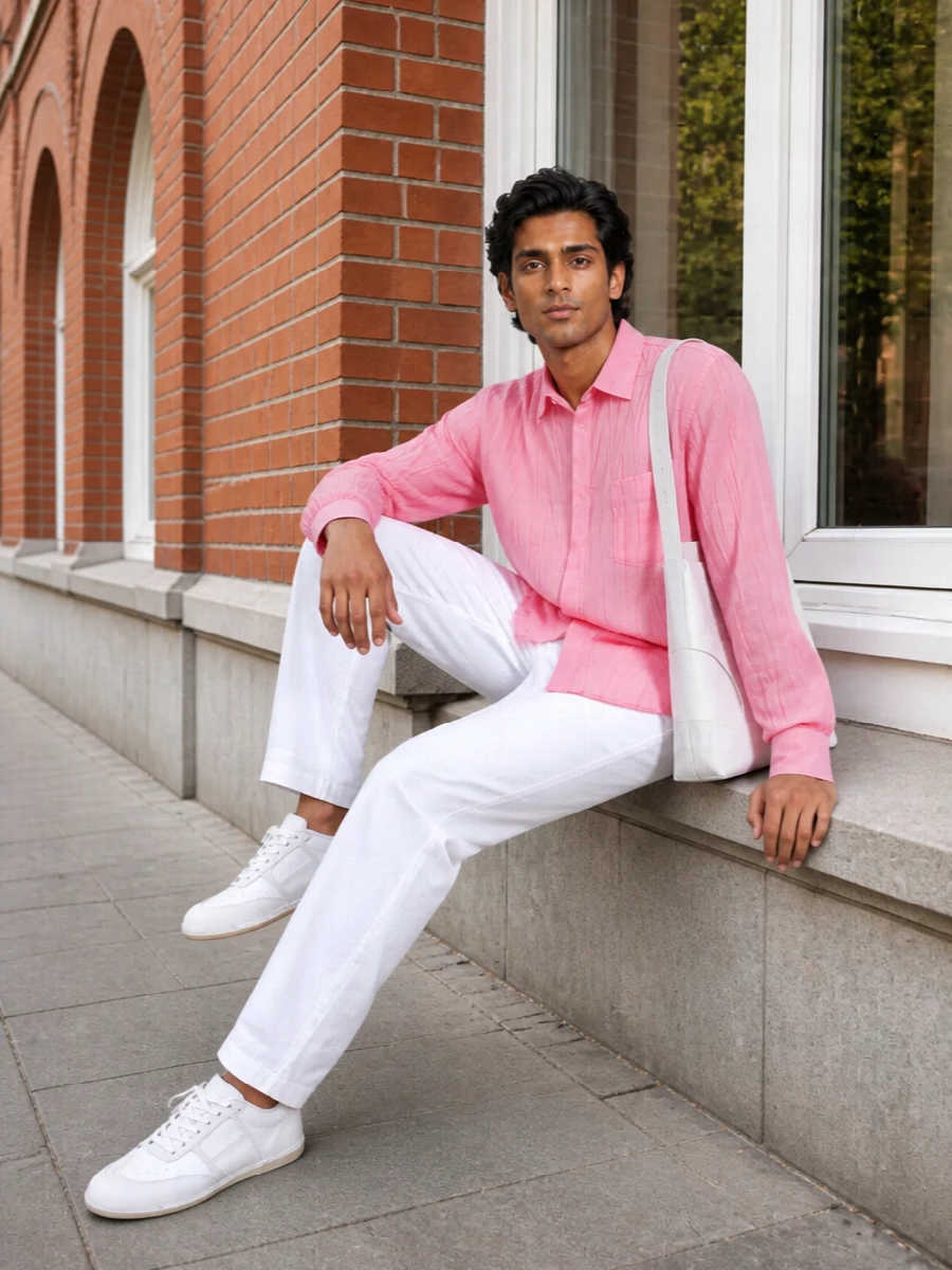 A crinkled bubblegum Moschino shirt sits over optic white denim for a fresh, graphic take on warm weather dressing. Soft white sneakers keep the line clean and relaxed, while a sculptural white shoulder bag brings a precise, design-led note. The result is a polished but easy city outfit that feels bright without tipping into novelty.