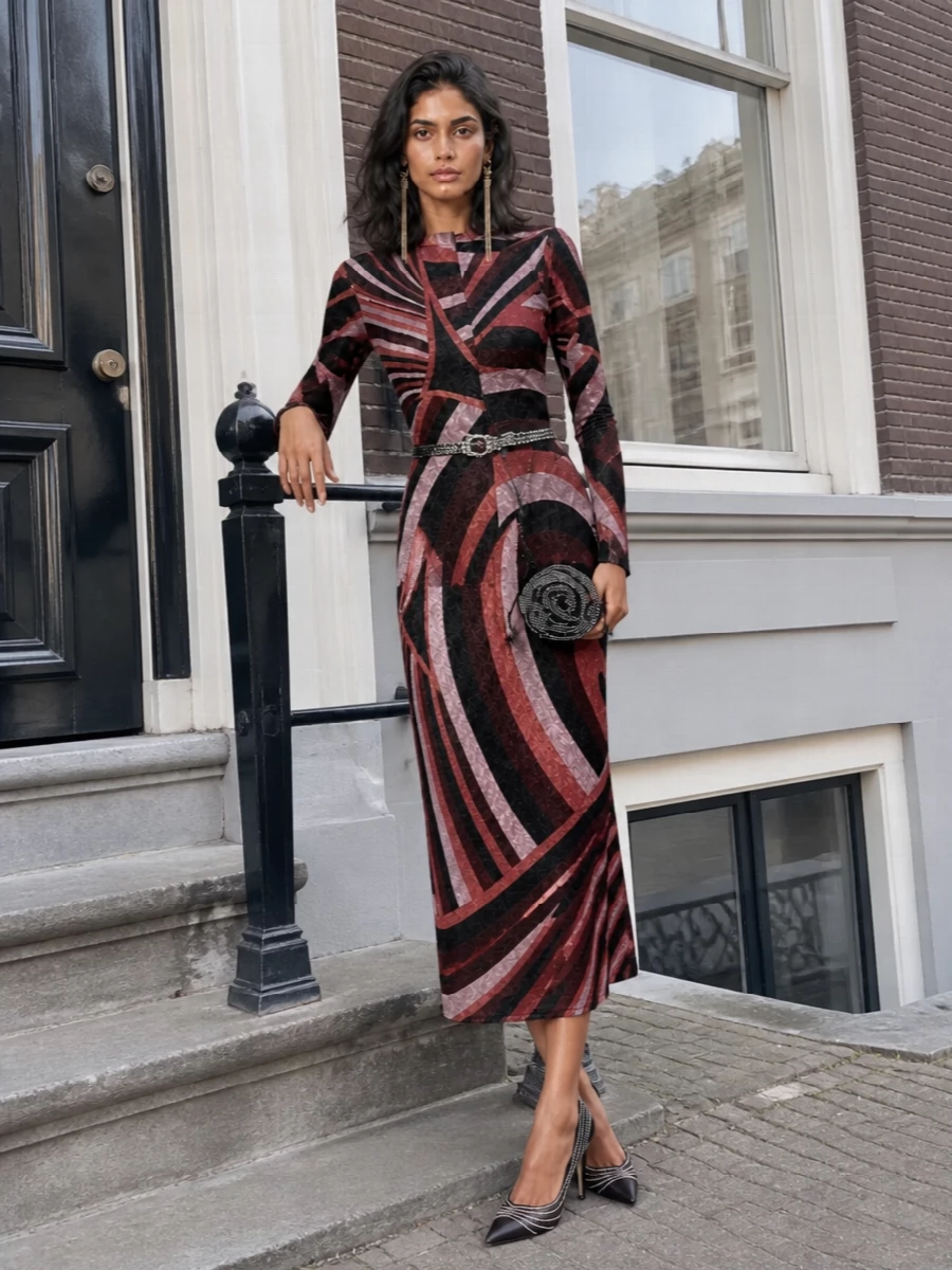 Pucci’s sculpted midi is the star, so everything around it stays graphic, dark and precise. Black crystal pumps and a rhinestone rose pouch echo the dress’s shimmer without stealing focus, while a crystal belt and long gold tassel earrings sharpen the waist and neckline for a polished, night-out finish.