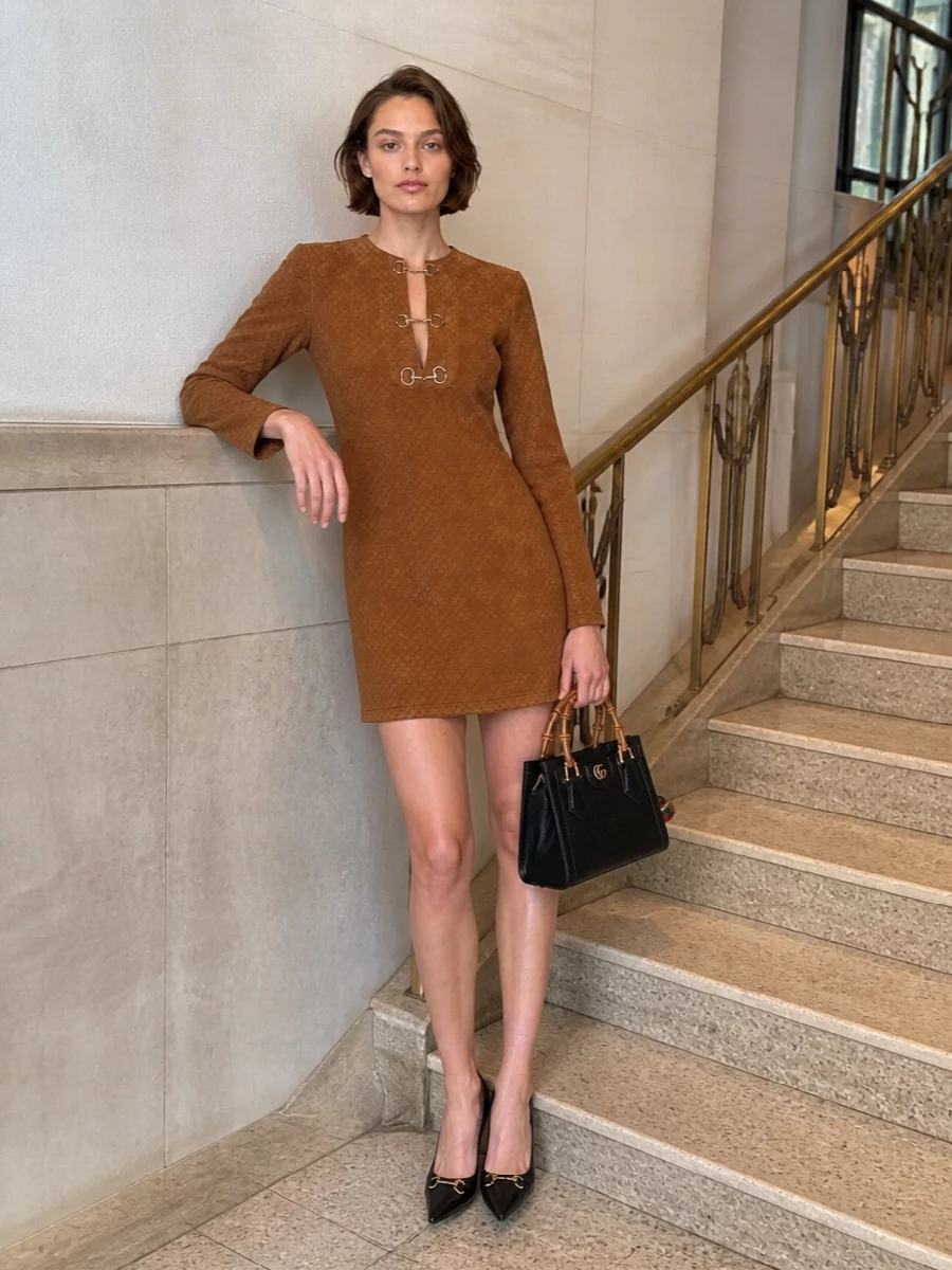 The GG camel mini shift and black pumps frame the bamboo-handle tote in a precise, heritage-driven palette of camel, black and gold. Choosing the dress route keeps the silhouette clean and tailored, with the house hardware doing the quiet storytelling. It is ideal for city dinners or smart daytime events where you want refined ease with clear Gucci signatures.