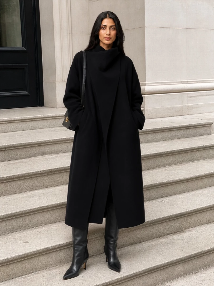 I anchored this around the dress path so the coat can read as a sculptural outer layer over a single, elongated column in deep black. The knit midi dress, sharp knee boots and structured shoulder bag create a quietly assertive city uniform that moves easily from desk to late dinner without breaking the coat’s clean architecture.