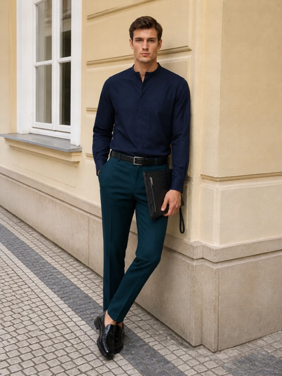 Deep teal tailoring meets midnight navy in a controlled, tonal palette that feels polished without reading stiff. The mandarin-collar shirt keeps the lines clean up top, letting the trousers carry the subtle colour statement. Glossy black accessories frame everything with quiet precision, ideal for city dinners or gallery afternoons where you want refinement that reads as considered rather than loud.