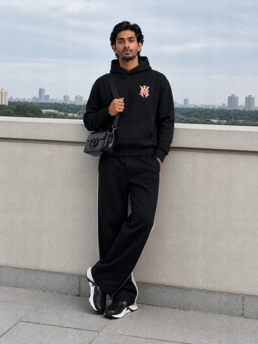 Amiri’s graphic hoodie sits over Palm Angels’ wide-leg trouser for a blacked-out street set that feels relaxed but deliberate. Fendi’s technical runners bring a precise, athletic edge under the pooling hem, while the Valentino shoulder bag keeps the whole mix sharp and low-key luxe. It is an easy city uniform for travel, studio days or late-night runs where comfort and attitude have to coexist.