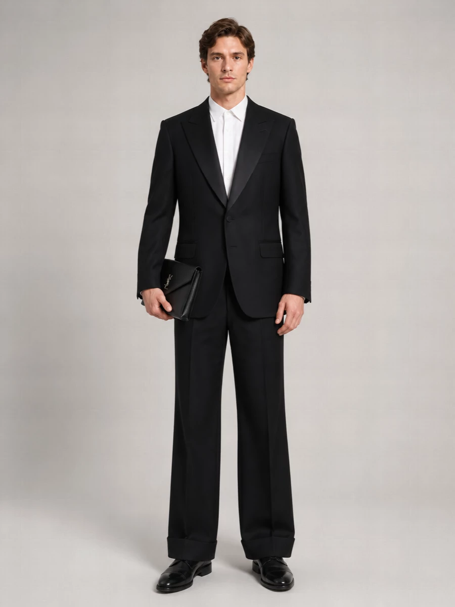 A modern black-tie ensemble that quietly sharpens Gucci’s relaxed tux mood with Valentino’s cuffed trouser and a classic Church’s Oxford. The result is formal, streamlined and subtly architectural, finished with a Saint Laurent envelope clutch that keeps everything focused and refined in hand.