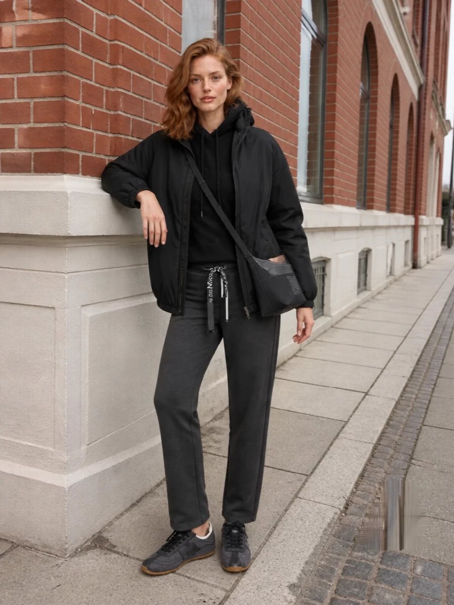 I’m building around the bomber’s original intent, so I chose the top and bottom route instead of a dress to keep the mood firmly off-duty and functional. The black hooded knit and charcoal joggers create a tonal knit-sport column under the technical shell, then the charcoal runner and compact crossbody keep everything light, hands free, and cohesive for travel or city days. It is quietly branded, minimal, and comfortable without losing that clean Max Mara precision in line and proportion.