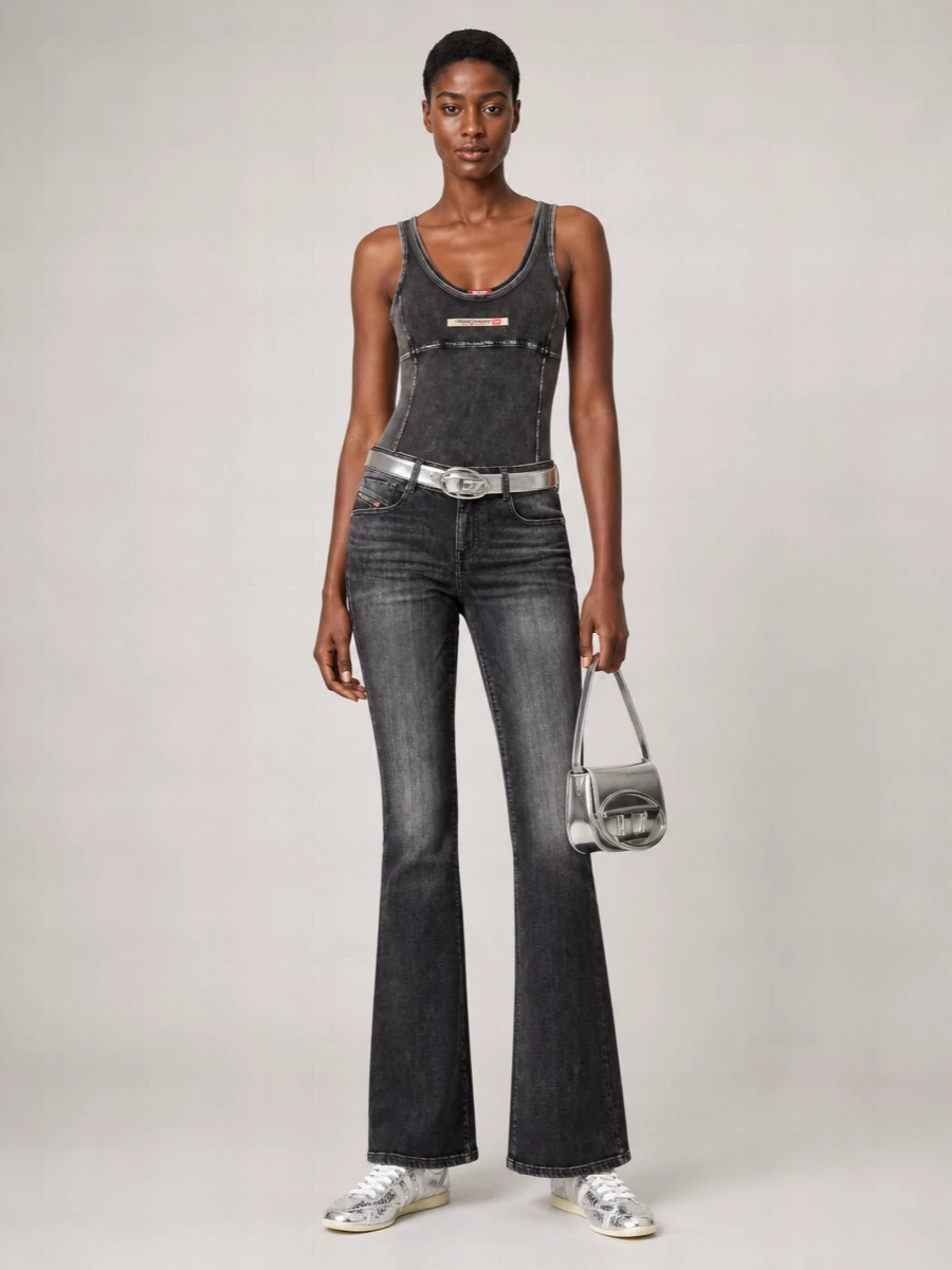 Charcoal flares and the second-skin bodysuit create a long, smoky line that feels straight out of an early‑2000s night in the city. Metallic sneakers keep it grounded but still ready for the dance floor, with the silver bag and crinkled belt catching light and echoing each other for a tight, graphic finish. It is a low-effort, high-impact Diesel uniform that moves easily from daytime roaming to late-night clubs just by adding gloss on top of grit.
