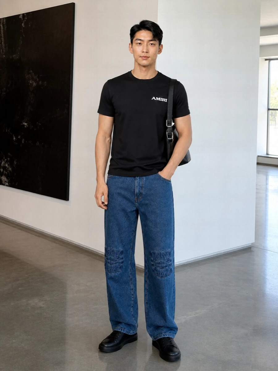 A black Amiri tee sits against relaxed indigo Loewe denim for a clean, low-contrast take on streetwear that still reads deliberately put together. Y-3’s tonal sneakers keep the silhouette grounded and graphic, while the Loewe shoulder bag adds a quiet, design-led note without breaking the monochrome mood. It is an easy uniform for city days where you want polish but still move like you are off duty.