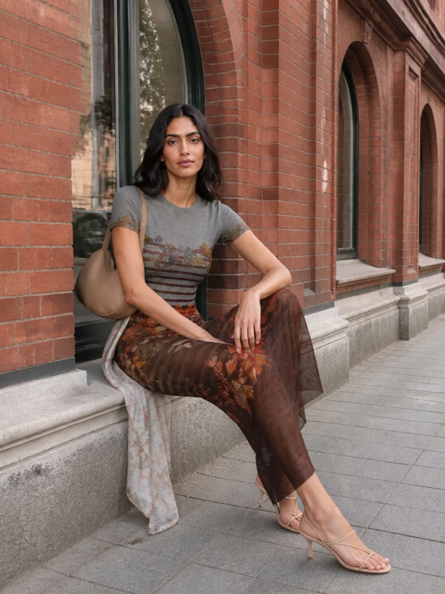 A head-to-toe Gaultier mesh story turns the classic marinière into something moody and romantic, the sheer floral maxi echoing the tee’s stripes and fruit in a long, liquid line. Nude slingbacks and a padded camel baguette keep the palette warm and neutral so the print can stay the focus, while still feeling easy enough for gallery days that drift into late dinners. A soft floral scarf adds just a hint of extra texture and color, like the final brushstroke on an artwork-inspired outfit.